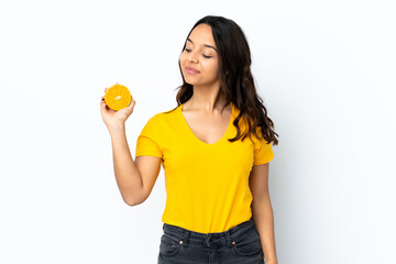 Young woman over isolated white background holding an orange