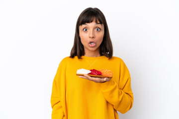 Young mixed race woman holding sashimi isolated on white background with surprise facial expression