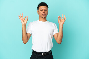 Young African American man isolated on blue background in zen pose