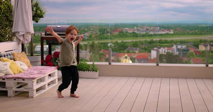 excited boy hones skills in walking on hands, front flip trick at the patio in the summer evening
