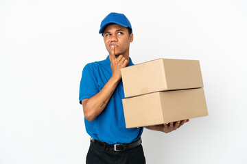 Delivery African American man isolated on white background having doubts while looking up