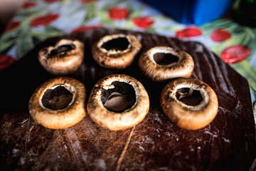 Shallow depth of field (selective focus) details with brown mushrooms (Agaricus bisporus) on a wooden plate ready to be cooked.