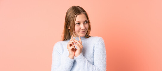 Teenager Ukrainian girl isolated on pink background scheming something - obrazy, fototapety, plakaty