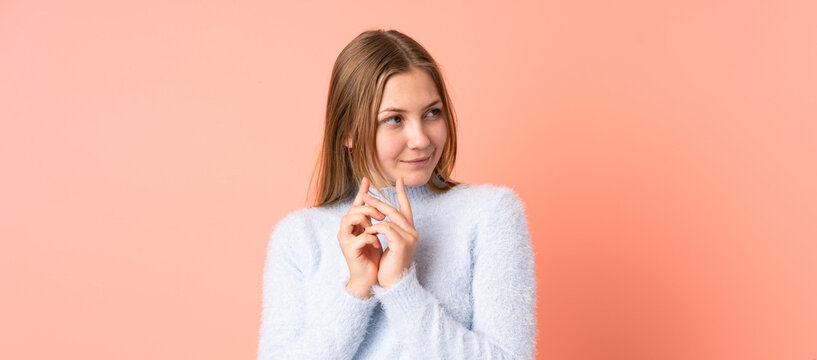 Teenager Ukrainian girl isolated on pink background scheming something
