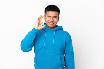Young Ecuadorian man isolated on white background showing ok sign with fingers