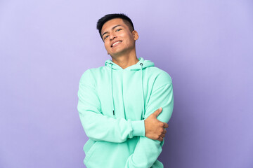 Young Ecuadorian man isolated on purple background laughing