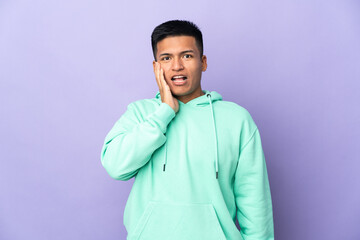 Young Ecuadorian man isolated on purple background with surprise and shocked facial expression