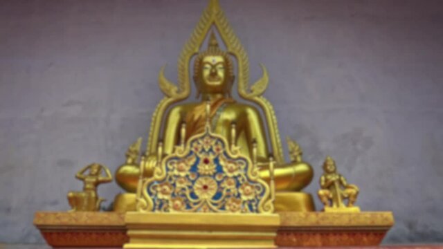 Blurred defocused view of golden Buddha statue, eighteen-cube Buddha. A Buddhist temple in the historical center of Chiang Mai.