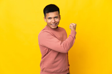 Young Ecuadorian man isolated on yellow background doing strong gesture