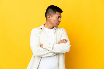 Young Ecuadorian man isolated on yellow background keeping the arms crossed