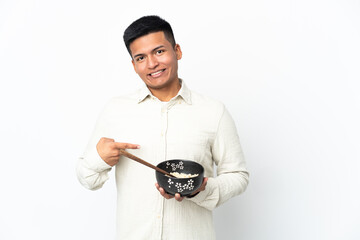 Young Ecuadorian man isolated on white background with surprise facial expression while holding a...