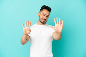 Naklejka premium Young caucasian man isolated on blue background counting nine with fingers
