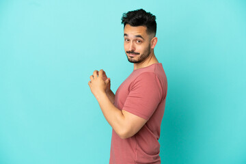 Young caucasian man isolated on blue background scheming something