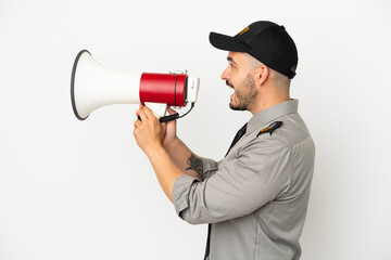 Young security  caucasian man isolated on white background shouting through a megaphone