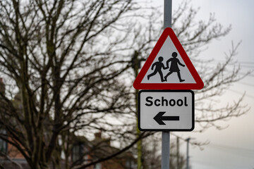 School crossing sign on a lamppost against a winter sky
