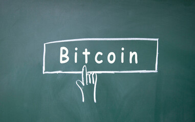 finger click bitcoin symbol on blackboard