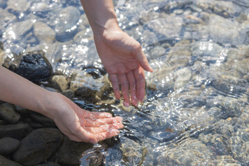 woman washing her hands in the river water