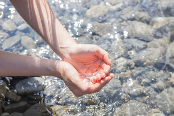 woman washing her hands in the river water