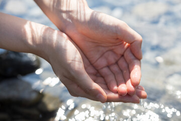 woman washing her hands in the river water