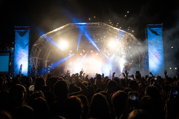 Concert with people enjoying, jumping, dancing,