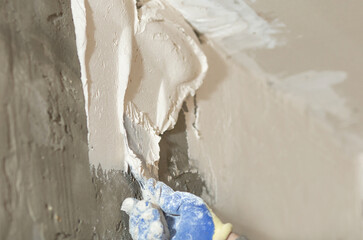 the process of smearing plaster mortar putty with a spatula on the wall close-up