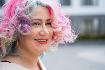 Close-up portrait of curly Caucasian woman with multi-colored hair. Model for hairstyles