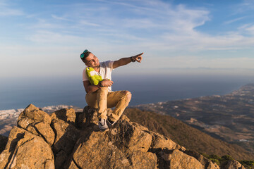 General view of a young man on top of Sierra Bermeja mountain with his best friend a teddy frog, Malaga