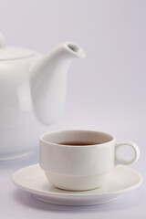 Cup of tea with teapot on white background