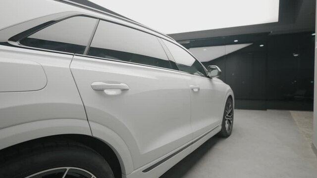 Side view of new white car in store. Action. Beautiful appearance of new white car in sales salon. Stylish Long car for sale