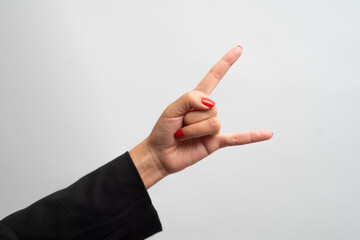 Female hand with red manicure shows gesture on white background