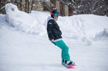 a girl on a snowboard rides down the side of the mountain