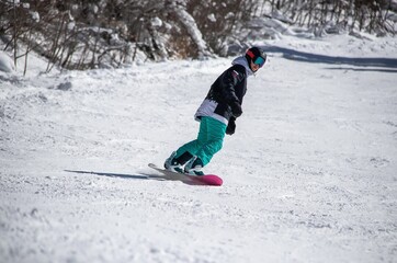 a girl on a snowboard rides down the side of the mountain