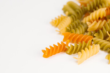  Colored fusilli or rotini variety of pasta formed in corkscrew or helical shapes on a white...