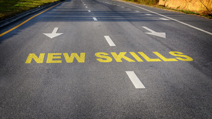 New skills word and white arrow on asphalt road. Reskilling and upskilling development concept and changing skill demand idea