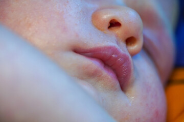 lips and mouth of a newborn sleeping baby. Face child close up view macro closeup. High quality photo