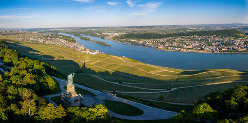 Luftaufnahme mit Drohne vom Niederwalddenkmal und Weinbergen bei Rüdesheim am Rhein während des Sonnenuntergangs and einem teilweise bewölkten Tag im Sommer, Rheingau Hessen