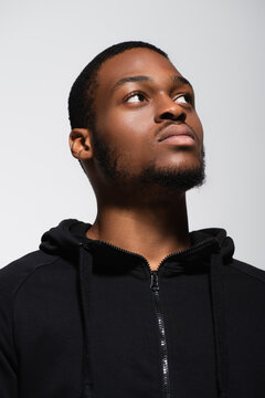 african american man in hoodie looking away isolated on grey.