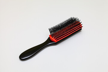 simple plastic comb black red on gray background