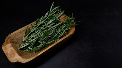 Fresh rosemary served in a wooden bowl isolated