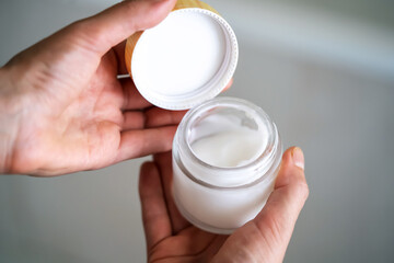 Girl holds a jar with a cream in her hands.