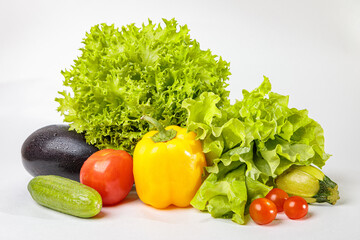 Set of fresh raw vegetables on a white background. Salad, tomatoes, cucumbers, eggplants, zucchini