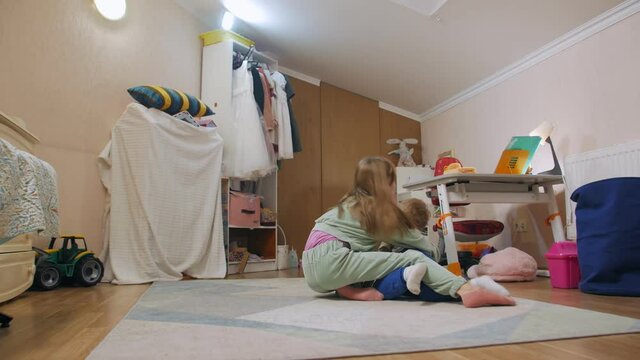 Girl offends little boy fighting on the floor