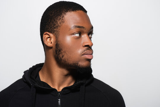 young african american man in hoodie looking away isolated on grey.