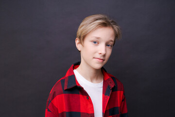 Close-up young smiling man in casual clothes in a red checkered shirt, posing isolated on background, studio portrait. People sincere emotions lifestyle concept. Copy space for copy.