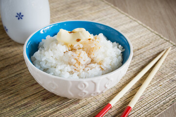 Japanese Uruchimai steamed rice with a knob of butter and soy sauce in a pretty ceramic bowl