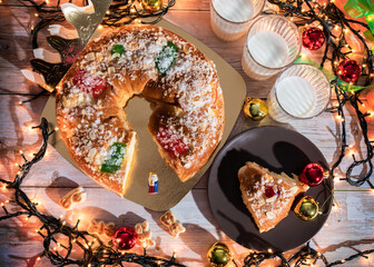 "Roscón de reyes" is a traditional Spanish Epiphany cake with decorative candied fruit and cream filling. Good luck figure inside. The Spanish concept of Three Kings Day. Three glasses of milk.