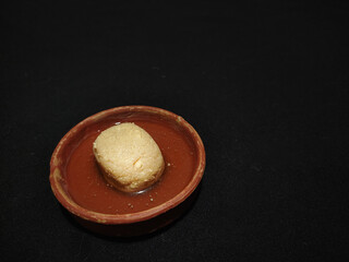 nolen gur rosogolla or rasgulla served on plate. brown spongy bengali indian traditional sweet made from cottage cheese and jaggery. winter special delicacy.