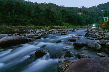 View of slow shutter speed water , Reshi River water flowing on rocks at dusk, Sikkim, India. Himalayan mountains.