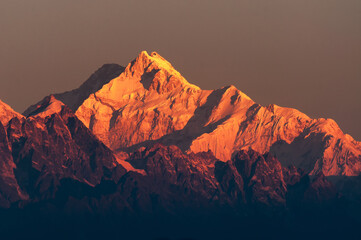Beautiful first light from sunrise on Mount Kanchenjugha, Himalayan mountain range, Sikkim, India. Orange tint on the mountains at dawn.