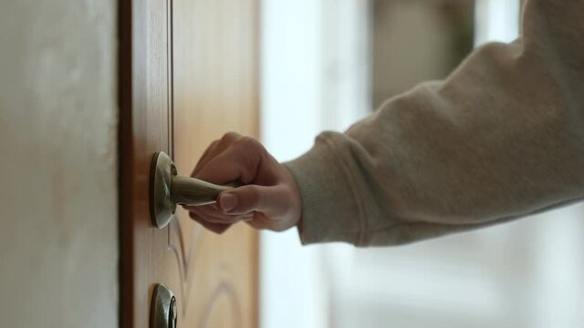 hand opens knob the door in the hotel house. business a service motel travel concept. tourist hand opens the door to the hotel room. door knob opens close-up apartments